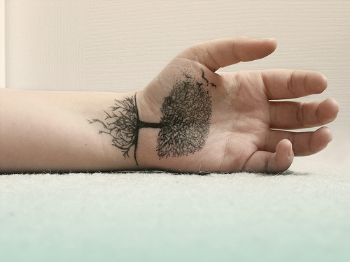 A-highly-detailed-tree-tattoo-on-the-palm-of-this-guys-hand-uses-the-line-between-the-wrist-and-palm-as-the-line-of-the-ground.